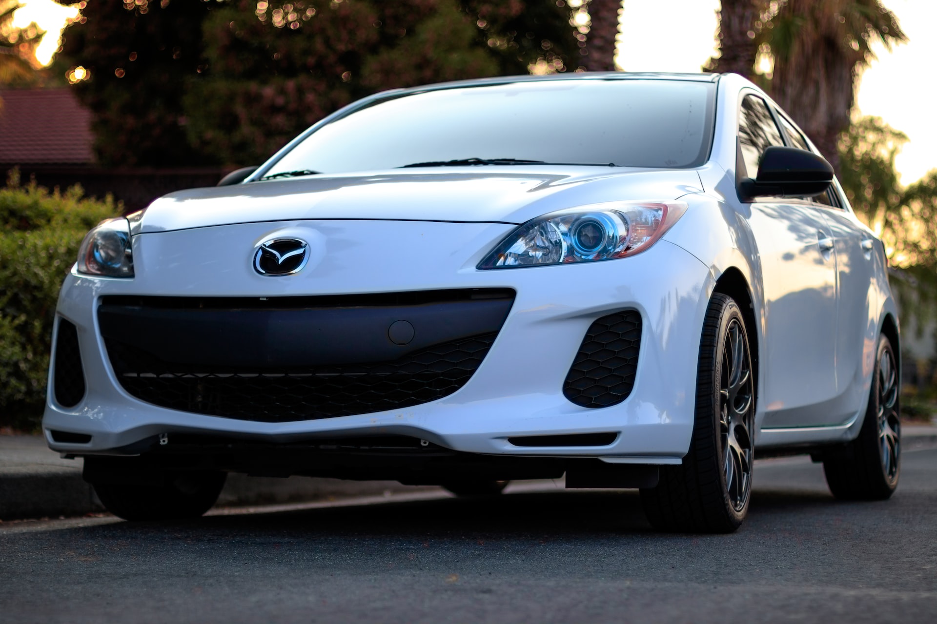 White mazda car parked in the street