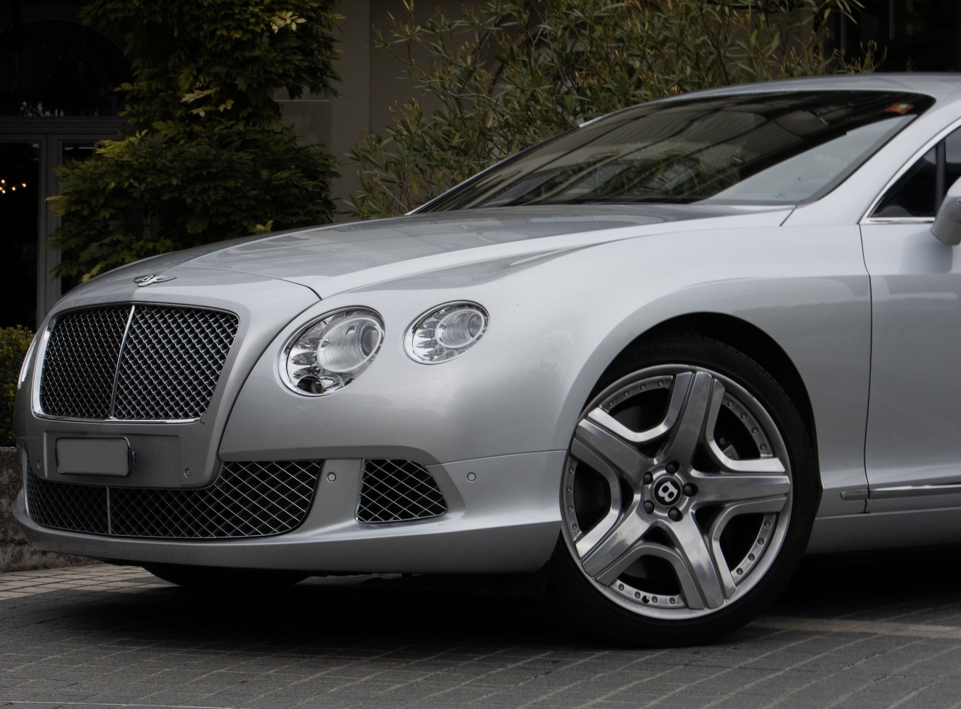 Silver Bentley car parked with wheel turn