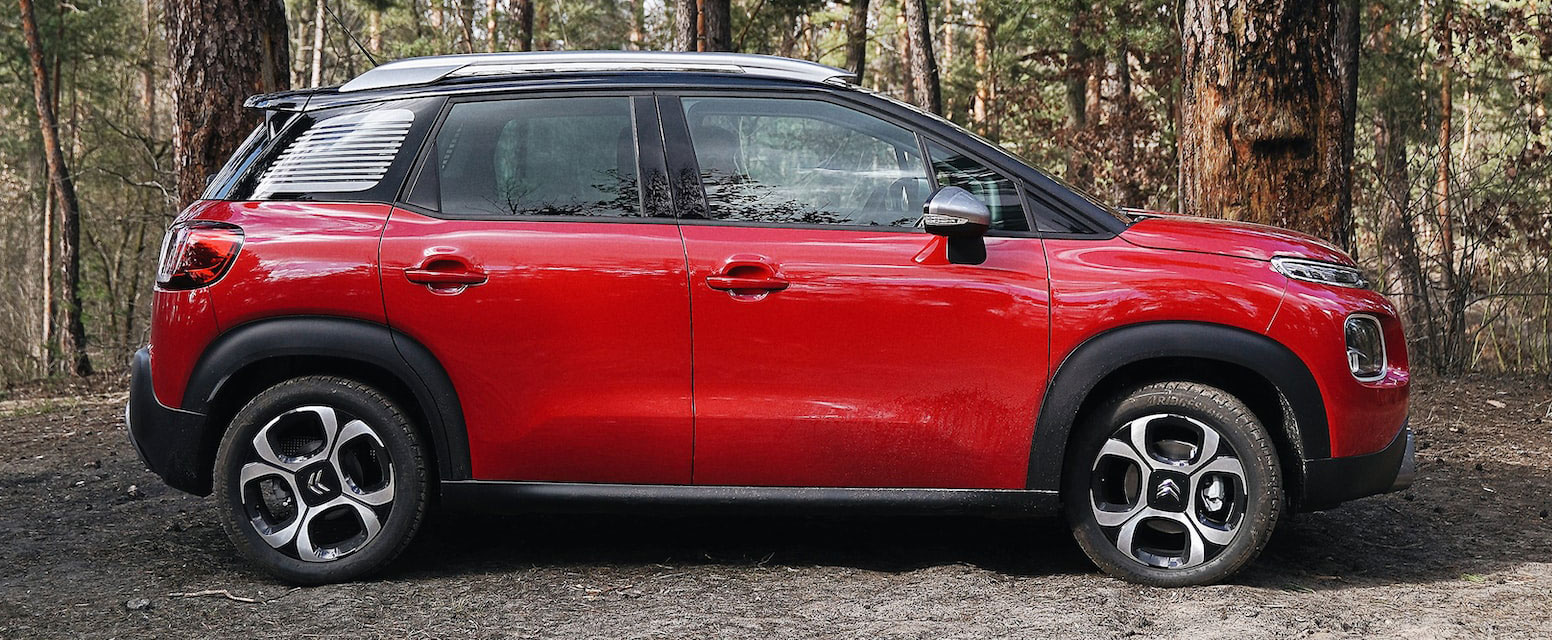 red Citroen parked on side in the woods