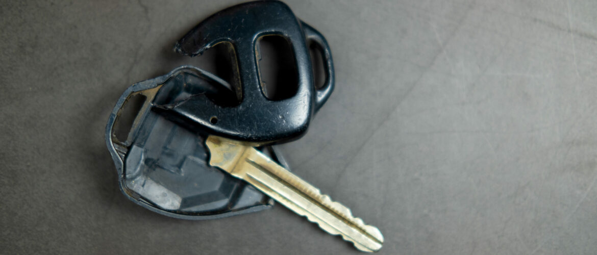 Close up dirty broken or damaged car remote key on black background
