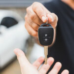 Vehicle locksmith, hands someone their replacement car key