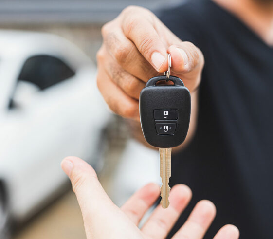Vehicle locksmith, hands someone their replacement car key