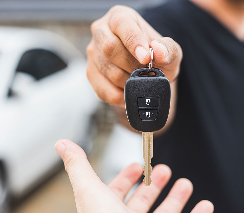 Vehicle locksmith, hands someone their replacement car key