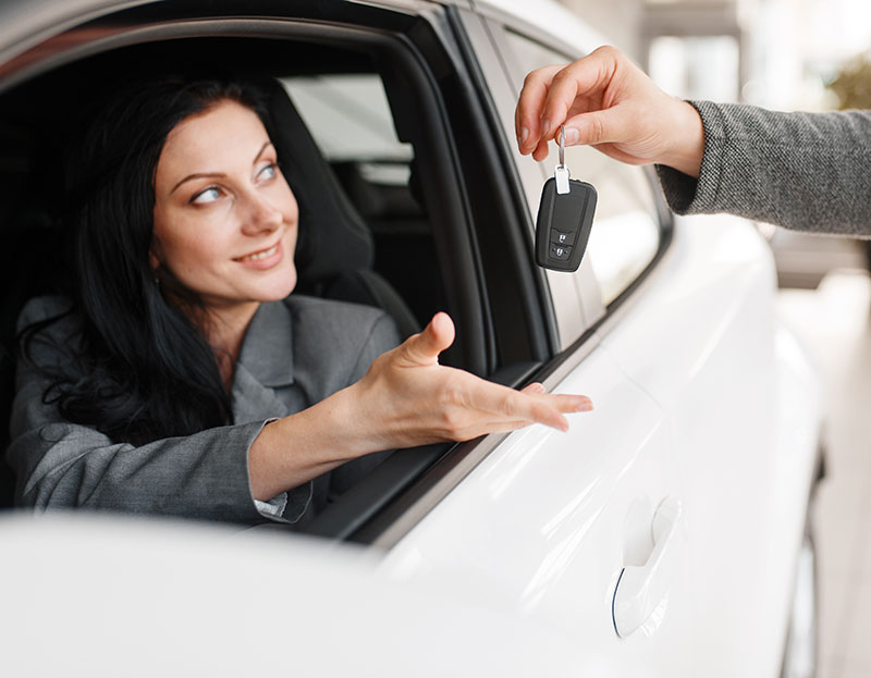 Woman sat in car being handed new car keys